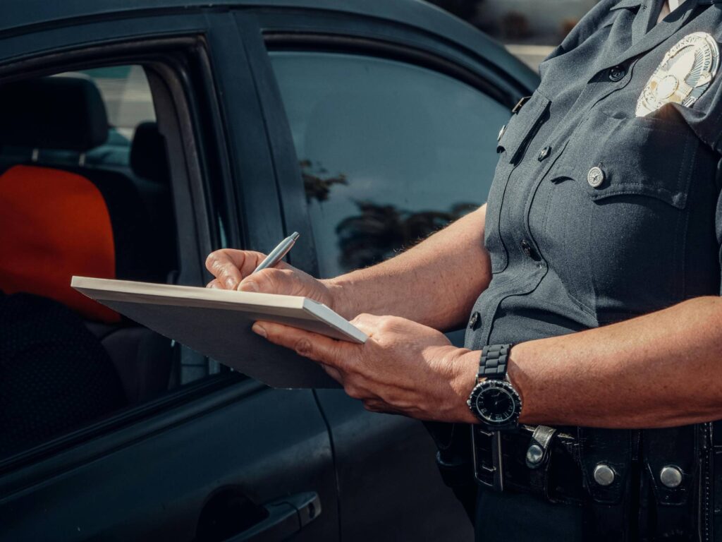 A police officer recording information on a clipboard.