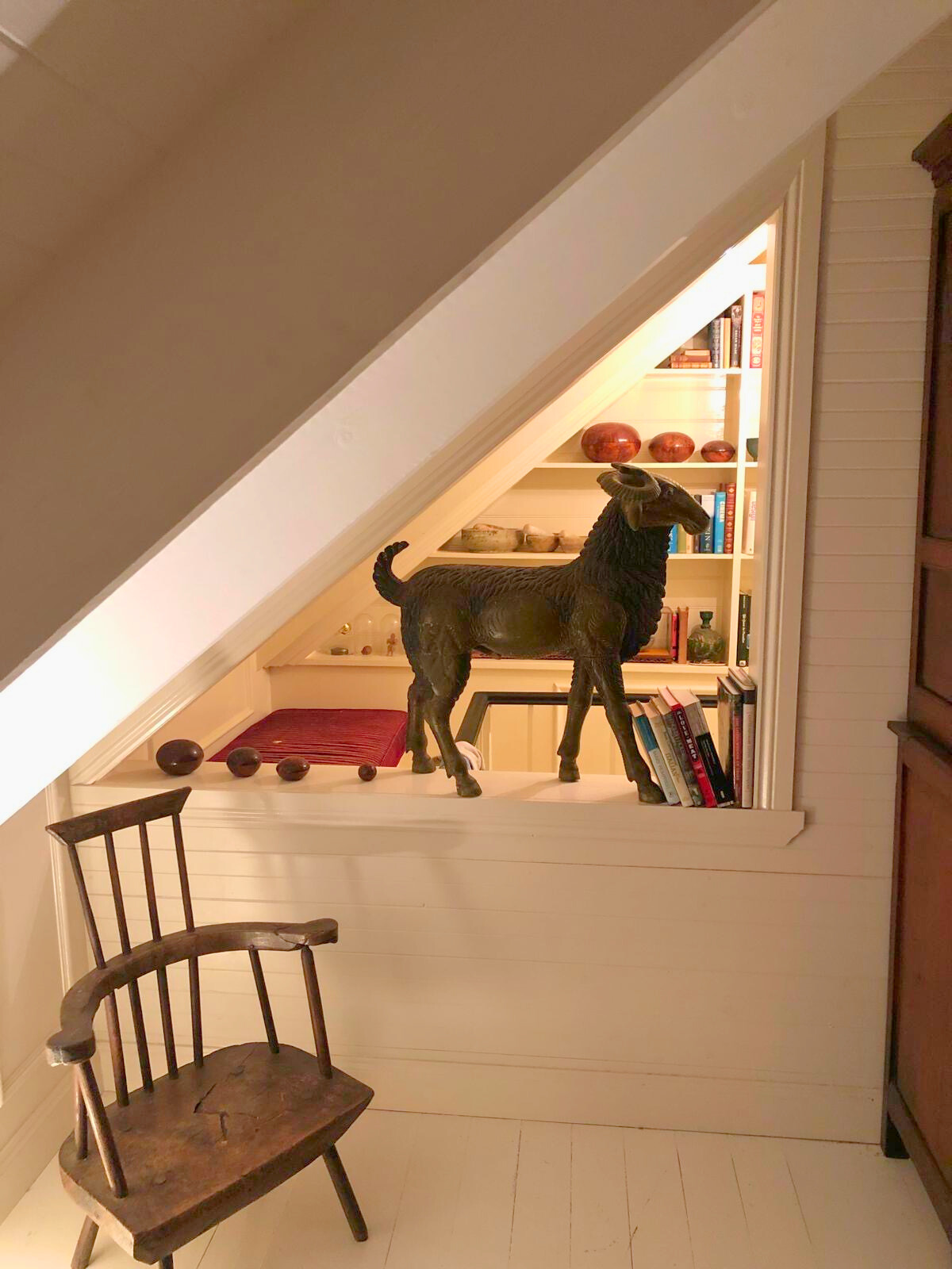 A wooden chair set in a room with a dog statue, part of the Follow Through House facility’s interior design. A wooden chair set in a room with a dog statue, part of the Follow Through House facility's interior design.