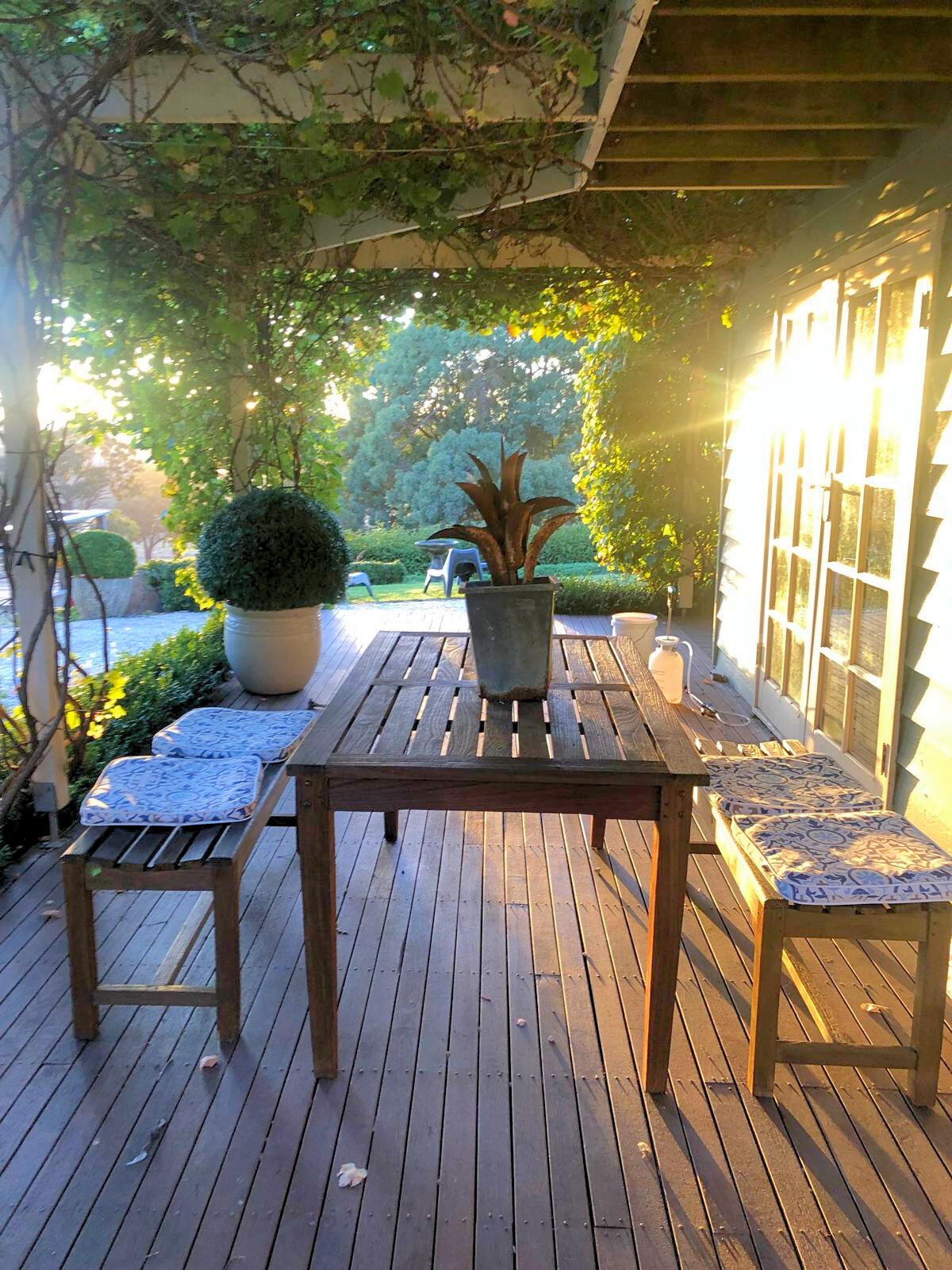 Outdoor setting featuring a table and two benches on a wooden deck at the Follow Through House facility. Outdoor setting featuring a table and two benches on a wooden deck at the Follow Through House (Women’s addiction recovery retreat) facility.