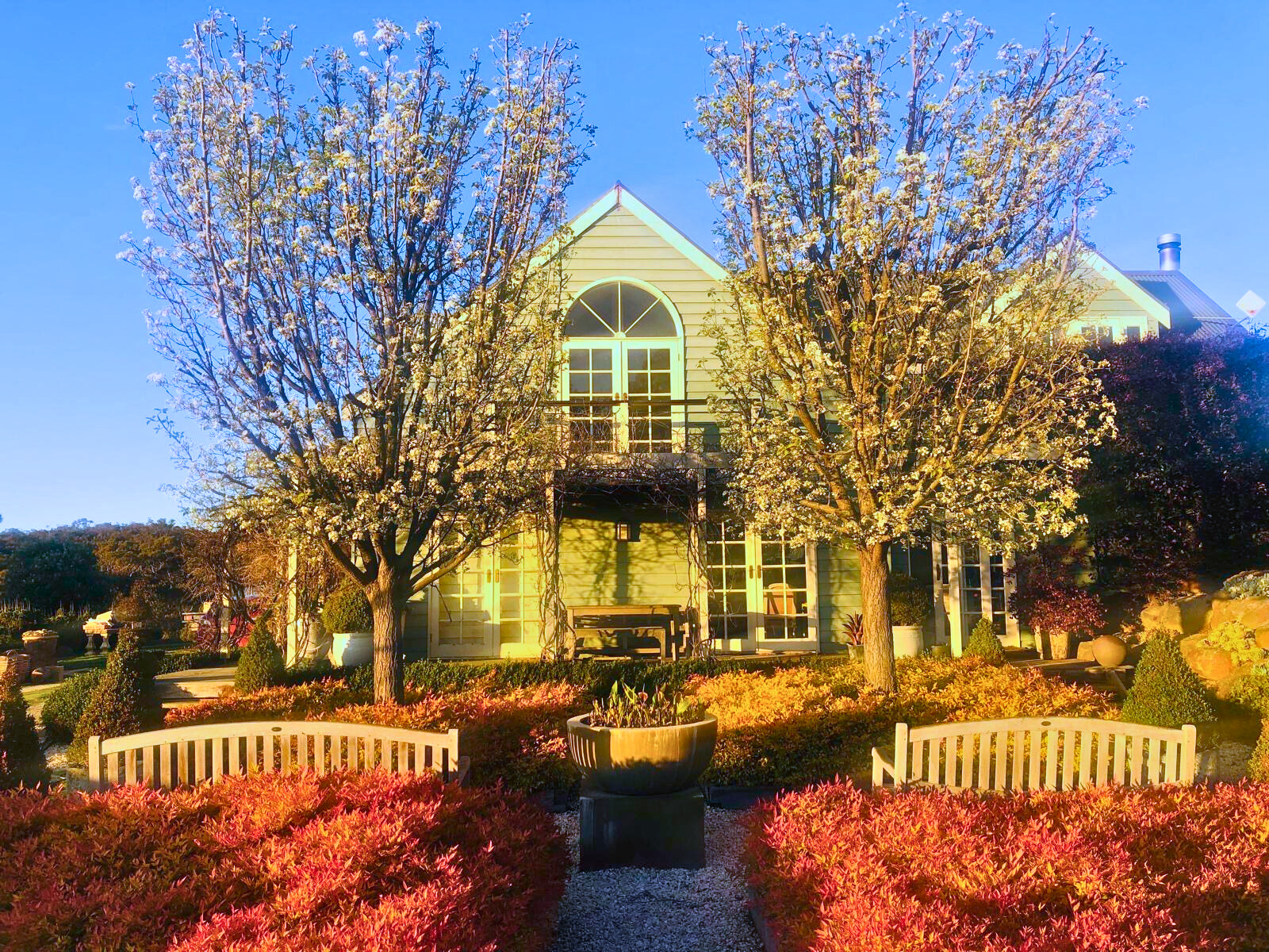 The Follow Through House facility features a charming house with a vibrant garden and trees in the background. The Follow Through House (Women’s addiction recovery retreat) facility features a charming house with a vibrant garden and trees in the background.