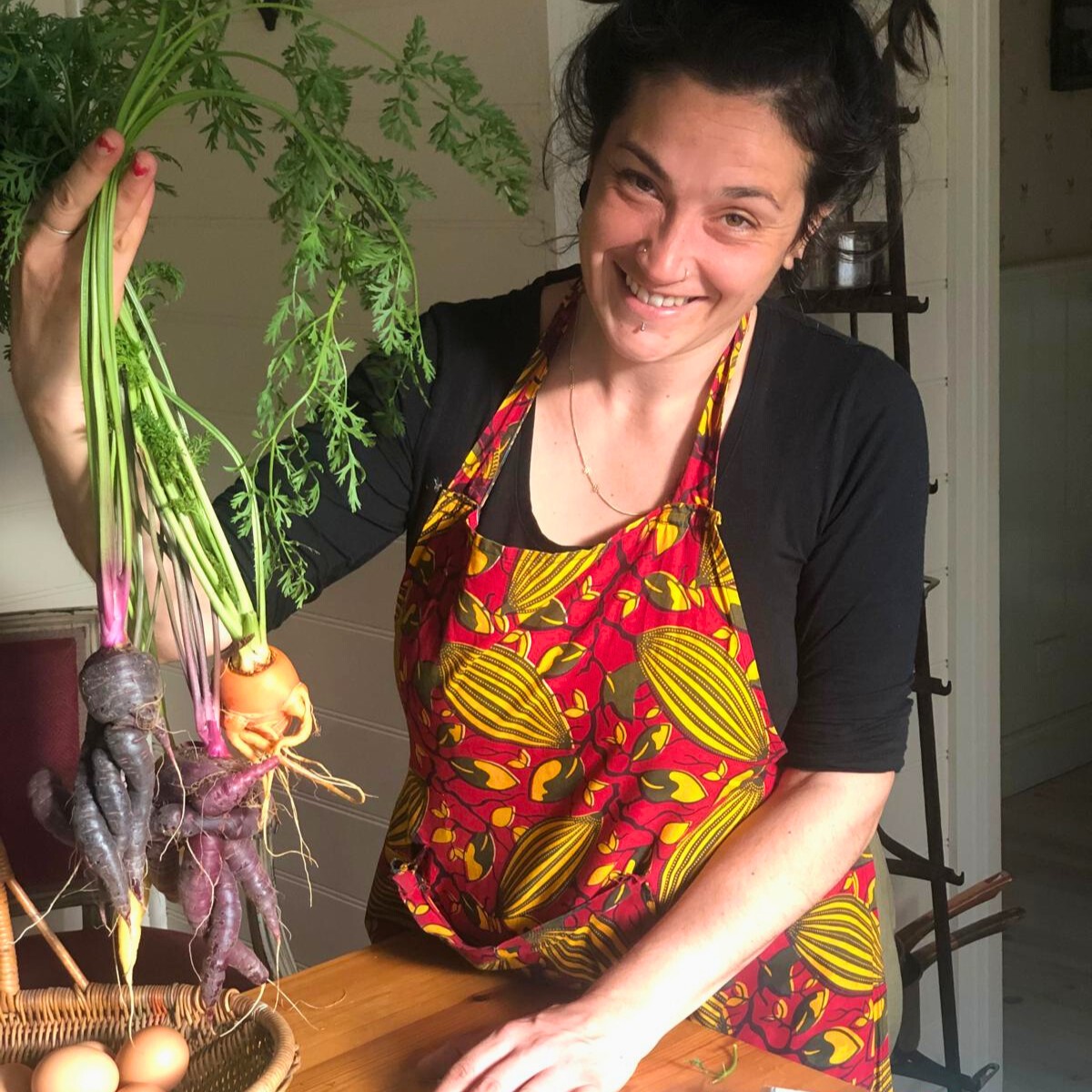 Alida proudly displays a basket of vegetables and eggs, highlighting the gardening activities at Follow Through House. This is part of Follow Through House's rehab & skill development programs.