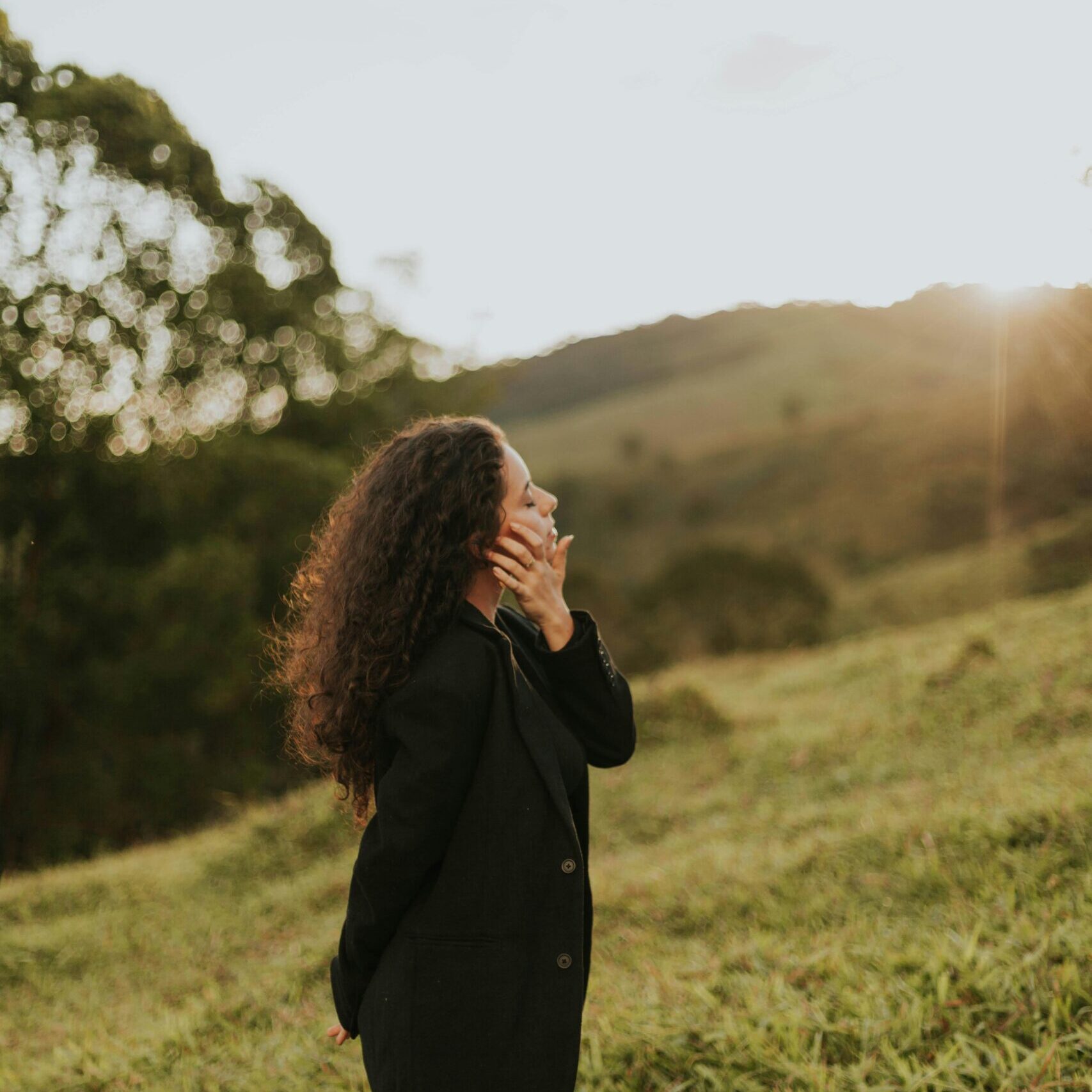 Side View of Woman Relaxing on Grass Hills
