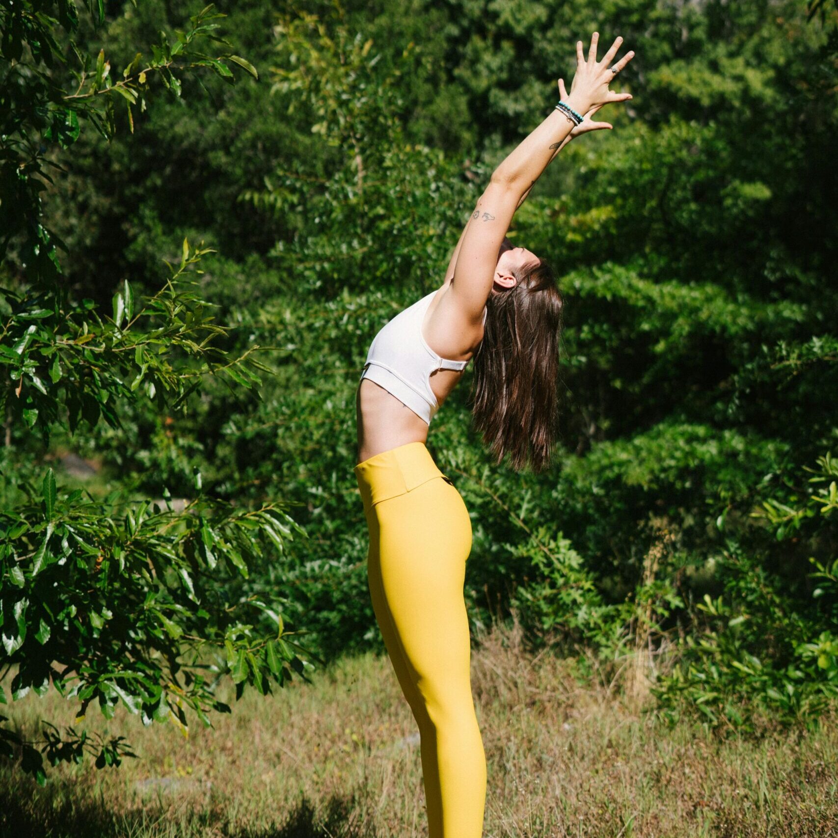 Woman in White Tank Top Raising Her Hands