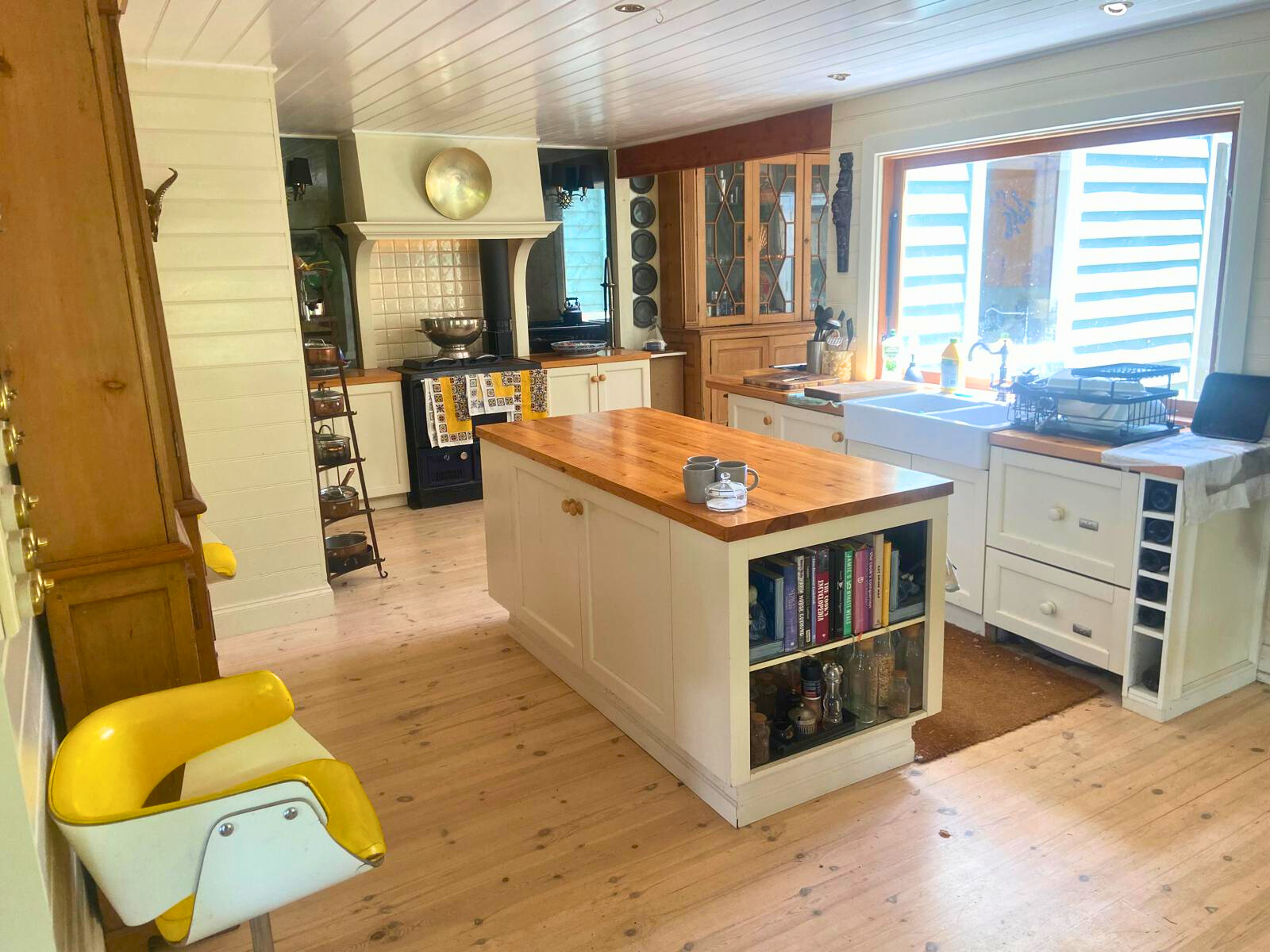 A kitchen featuring a wooden floor and a yellow chair, part of the Follow Through House facility. A kitchen featuring a wooden floor and a yellow chair, part of the Follow Through House facility.